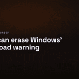 A warning label peeling off a plain sealed parcel on a flat surface